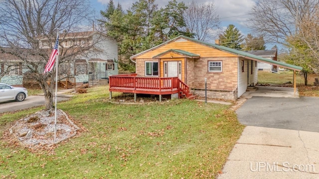 view of front of house with a carport, a front yard, and a wooden deck