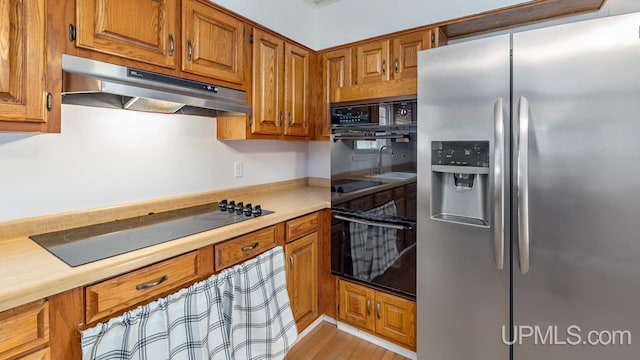 kitchen featuring light hardwood / wood-style flooring and black appliances