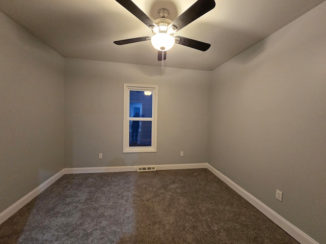 unfurnished room with ceiling fan and dark carpet