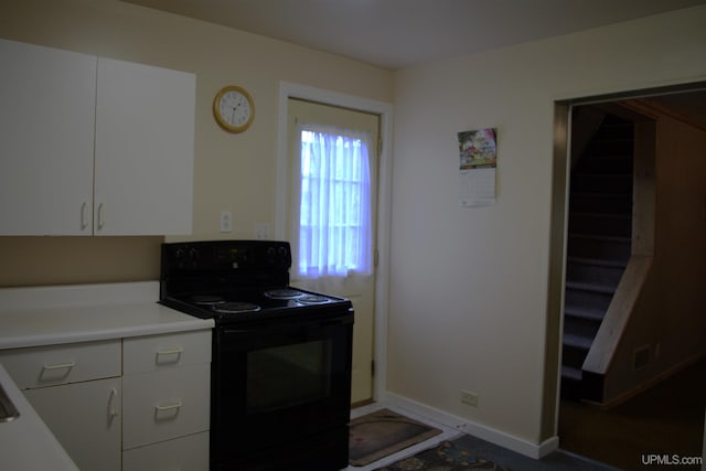 kitchen with white cabinetry and black electric range