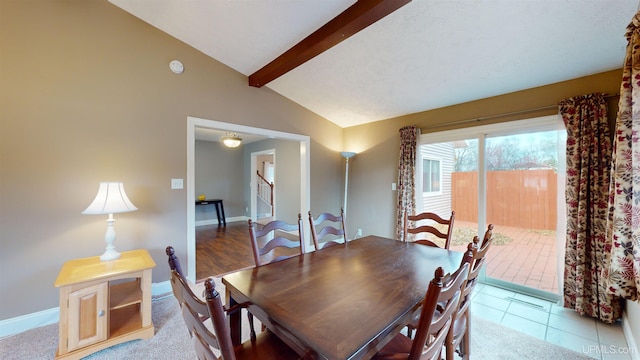 tiled dining room with lofted ceiling with beams