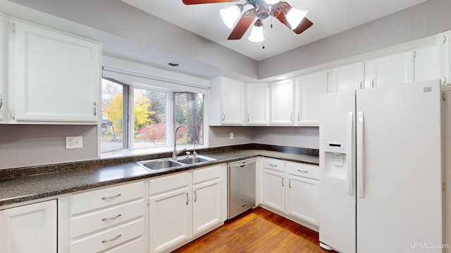 kitchen featuring white refrigerator with ice dispenser, white cabinetry, stainless steel dishwasher, and sink