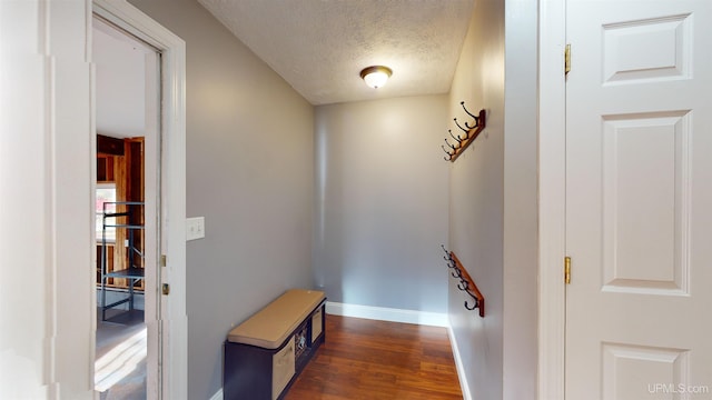 hall featuring a textured ceiling and dark hardwood / wood-style floors