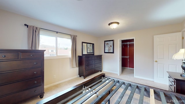 bedroom with a spacious closet, light carpet, and a closet