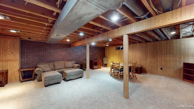 basement with wood walls, light colored carpet, and brick wall