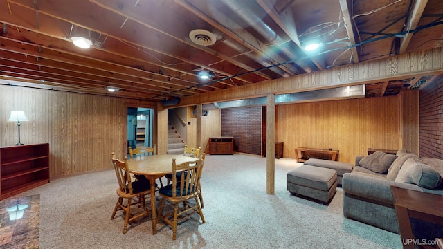 carpeted dining space featuring wooden walls and brick wall