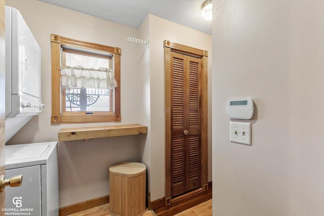 interior space with wood-type flooring and stacked washer and clothes dryer