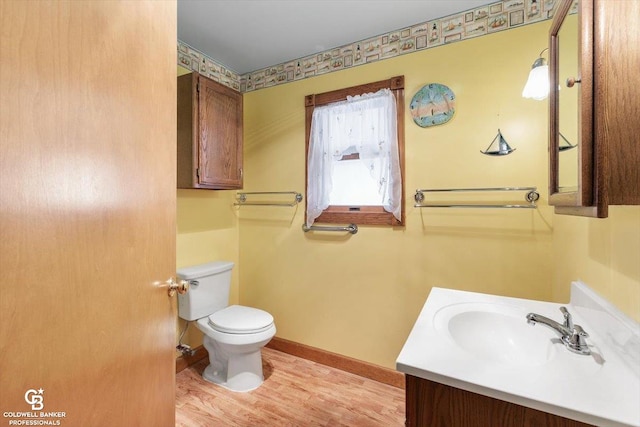 bathroom with vanity, hardwood / wood-style flooring, and toilet