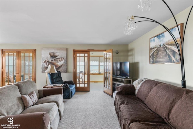 carpeted living room with a chandelier and french doors