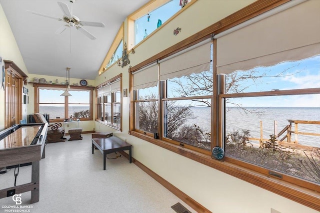 sunroom / solarium with ceiling fan, a water view, and lofted ceiling