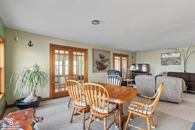 carpeted dining space with french doors