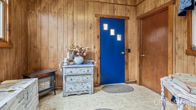 entryway with wood walls and light parquet flooring