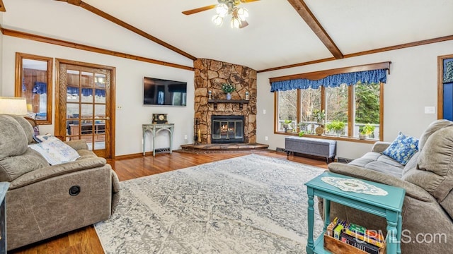 living room with a stone fireplace, ceiling fan, lofted ceiling with beams, and hardwood / wood-style flooring