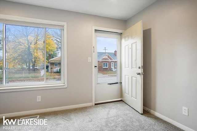 entryway featuring light carpet and a healthy amount of sunlight