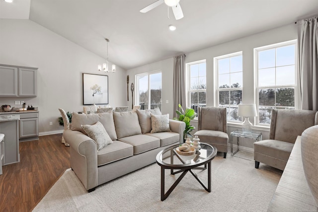 living room featuring ceiling fan with notable chandelier, dark hardwood / wood-style flooring, vaulted ceiling, and plenty of natural light