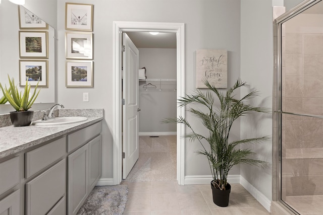 bathroom featuring tile patterned floors, vanity, and walk in shower