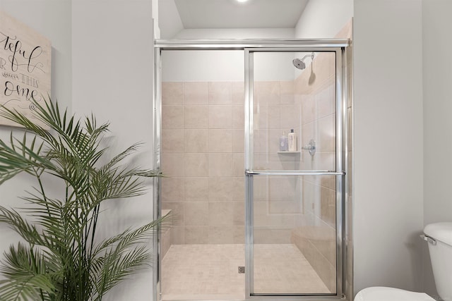 bathroom featuring toilet and an enclosed shower