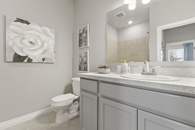 bathroom with tile patterned flooring, toilet, vanity, and walk in shower