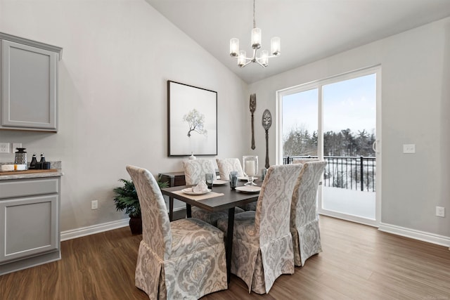 dining space featuring a notable chandelier, dark hardwood / wood-style flooring, and lofted ceiling