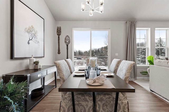 dining room with hardwood / wood-style floors and an inviting chandelier