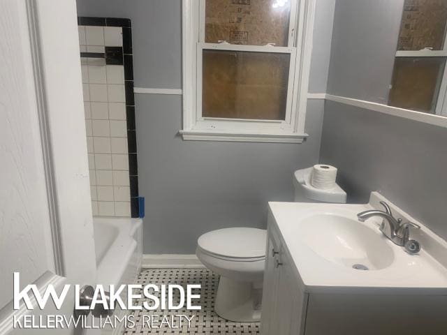 bathroom with tile patterned flooring, vanity, and toilet