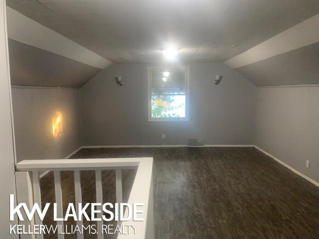 additional living space featuring hardwood / wood-style floors and lofted ceiling