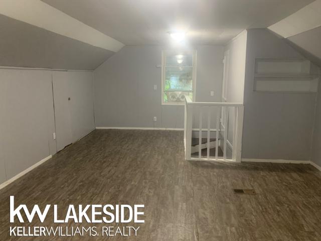 bonus room featuring dark hardwood / wood-style flooring and vaulted ceiling