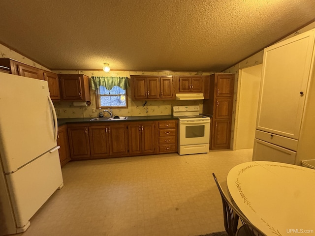 kitchen with a textured ceiling, white appliances, sink, and vaulted ceiling