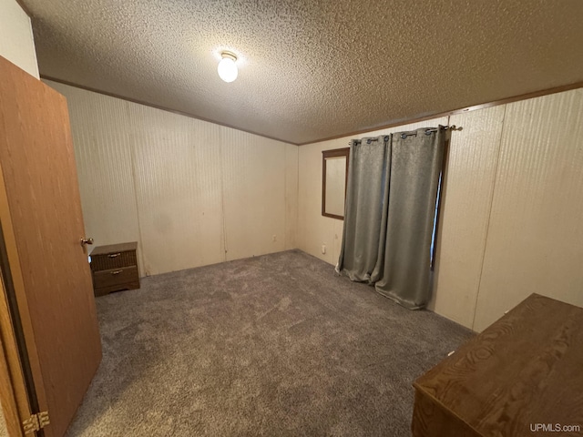 basement with dark colored carpet and a textured ceiling