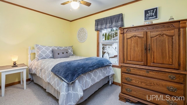 bedroom featuring ceiling fan, crown molding, and light carpet