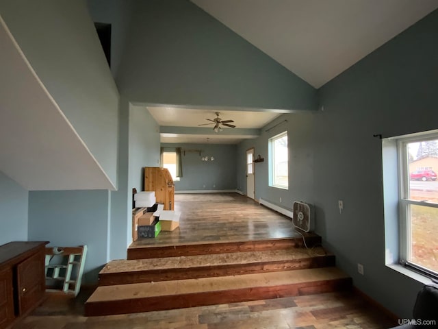 staircase with baseboard heating, ceiling fan, high vaulted ceiling, and wood-type flooring