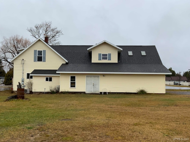 rear view of house featuring a yard and central AC unit