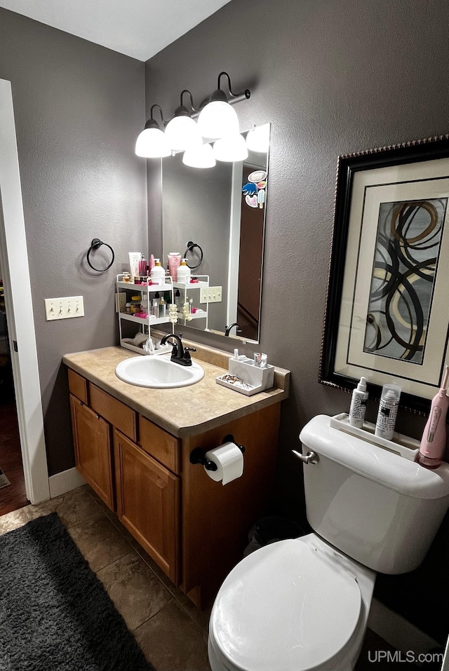 bathroom featuring tile patterned flooring, vanity, and toilet