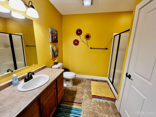 bathroom with vanity, a shower with shower door, and toilet