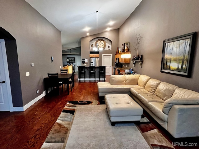 living room featuring dark wood-type flooring and vaulted ceiling