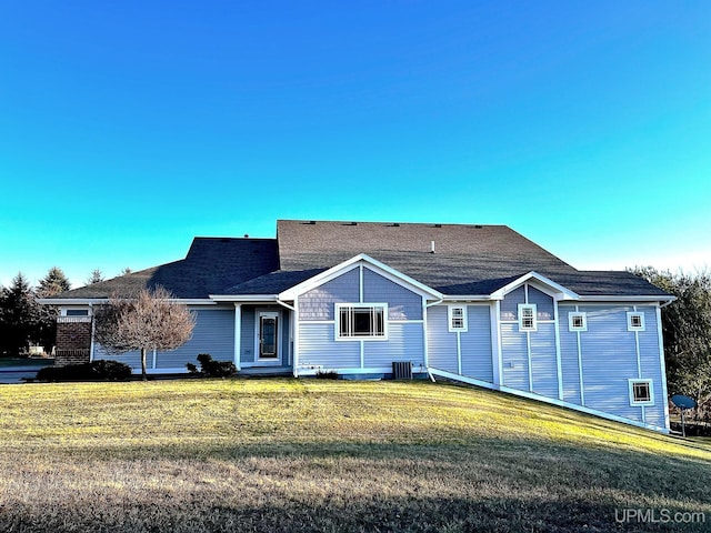 ranch-style home featuring central AC unit and a front lawn