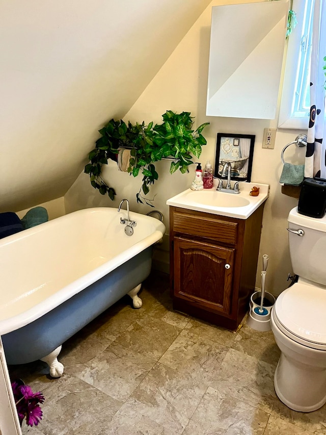 bathroom featuring lofted ceiling, a tub to relax in, toilet, and vanity