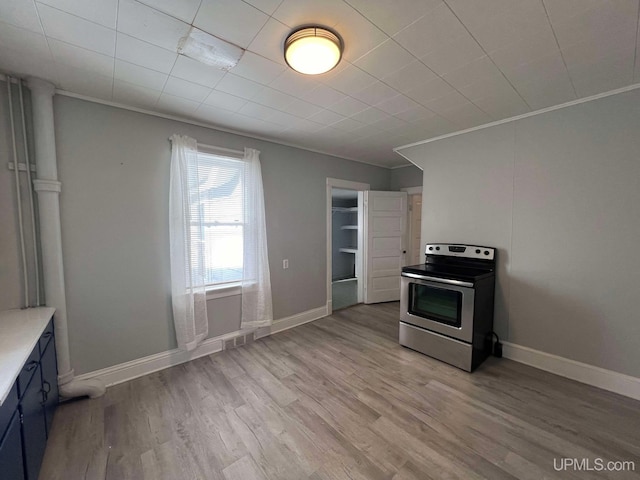 kitchen featuring light hardwood / wood-style flooring, stainless steel range with electric cooktop, and crown molding