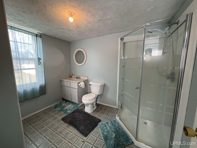 bathroom featuring vanity, a textured ceiling, toilet, and walk in shower