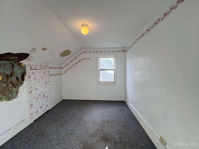 bonus room featuring a textured ceiling, carpet, and vaulted ceiling