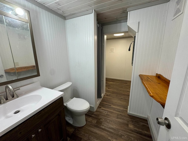 bathroom with wood walls, hardwood / wood-style floors, toilet, vanity, and wood ceiling