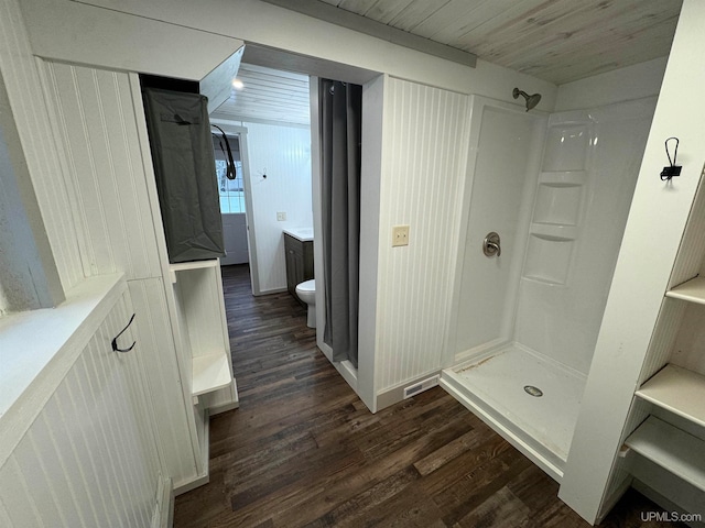 bathroom with a shower, hardwood / wood-style floors, vanity, and toilet