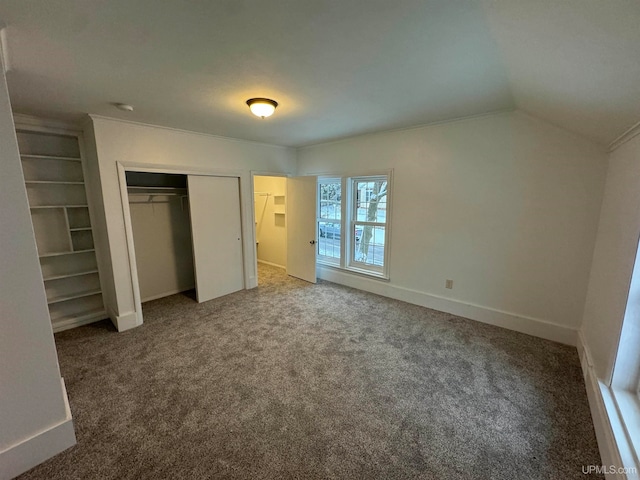 unfurnished bedroom with carpet floors, a closet, and lofted ceiling