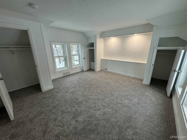 unfurnished bedroom featuring carpet flooring, a closet, and lofted ceiling