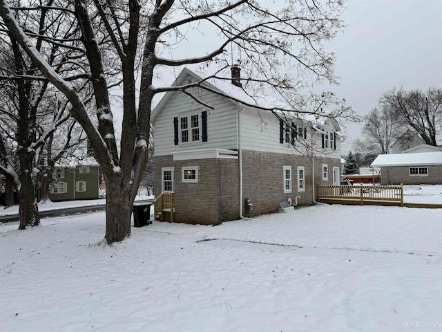 snow covered property with a wooden deck