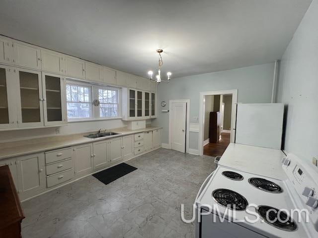 kitchen featuring white appliances, an inviting chandelier, white cabinets, sink, and decorative light fixtures