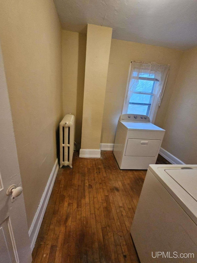 laundry room featuring dark wood-type flooring and radiator