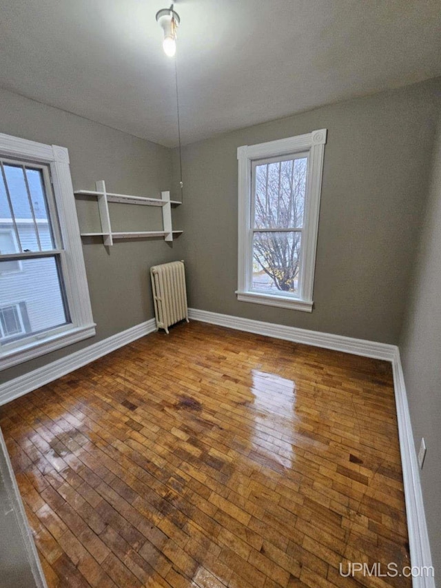 empty room featuring hardwood / wood-style floors and radiator