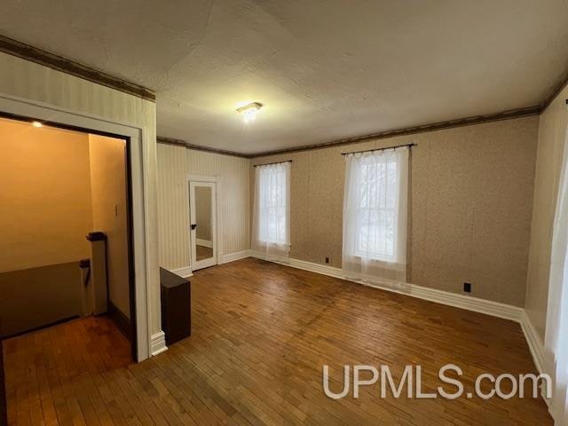 unfurnished bedroom featuring dark hardwood / wood-style floors and ornamental molding