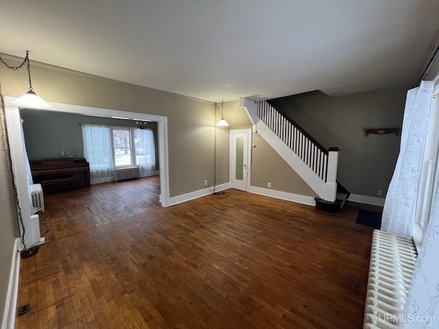 unfurnished living room featuring radiator and dark hardwood / wood-style flooring